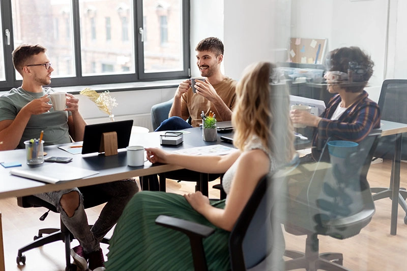 Kollegen trinken gemeinsam Kaffee in einem modernen Büro